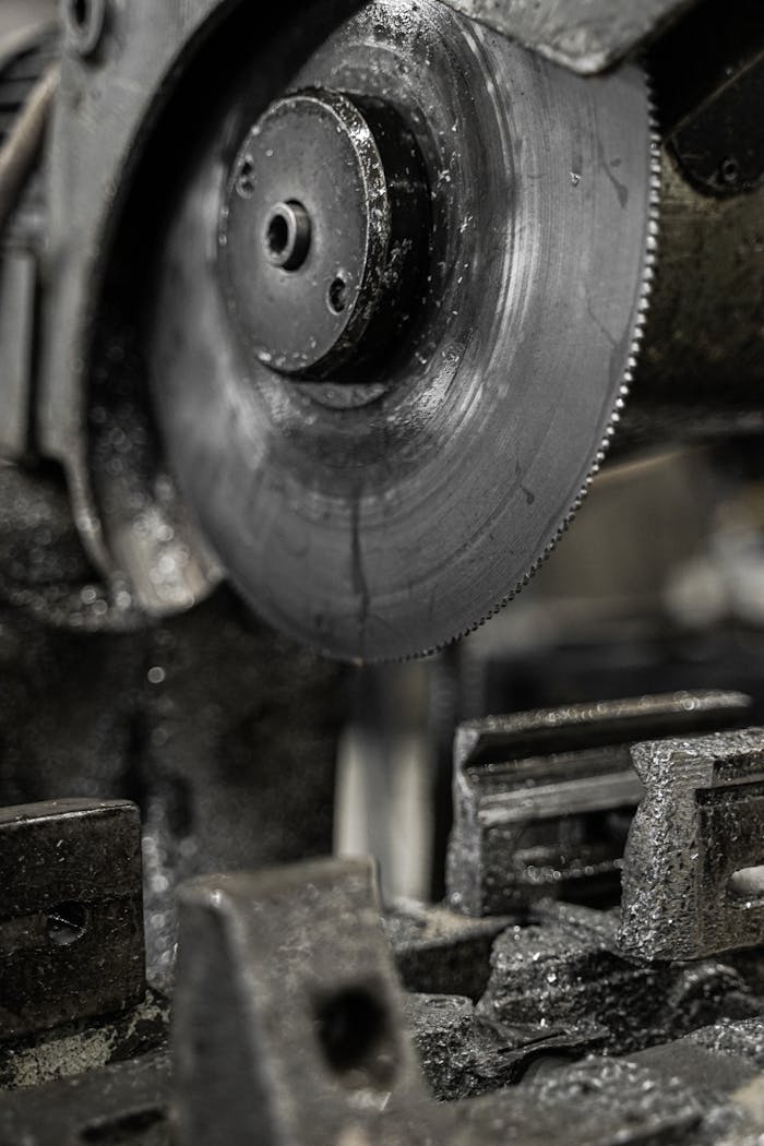 Detailed view of a circular saw blade in a factory setting, showcasing sharp precision.
