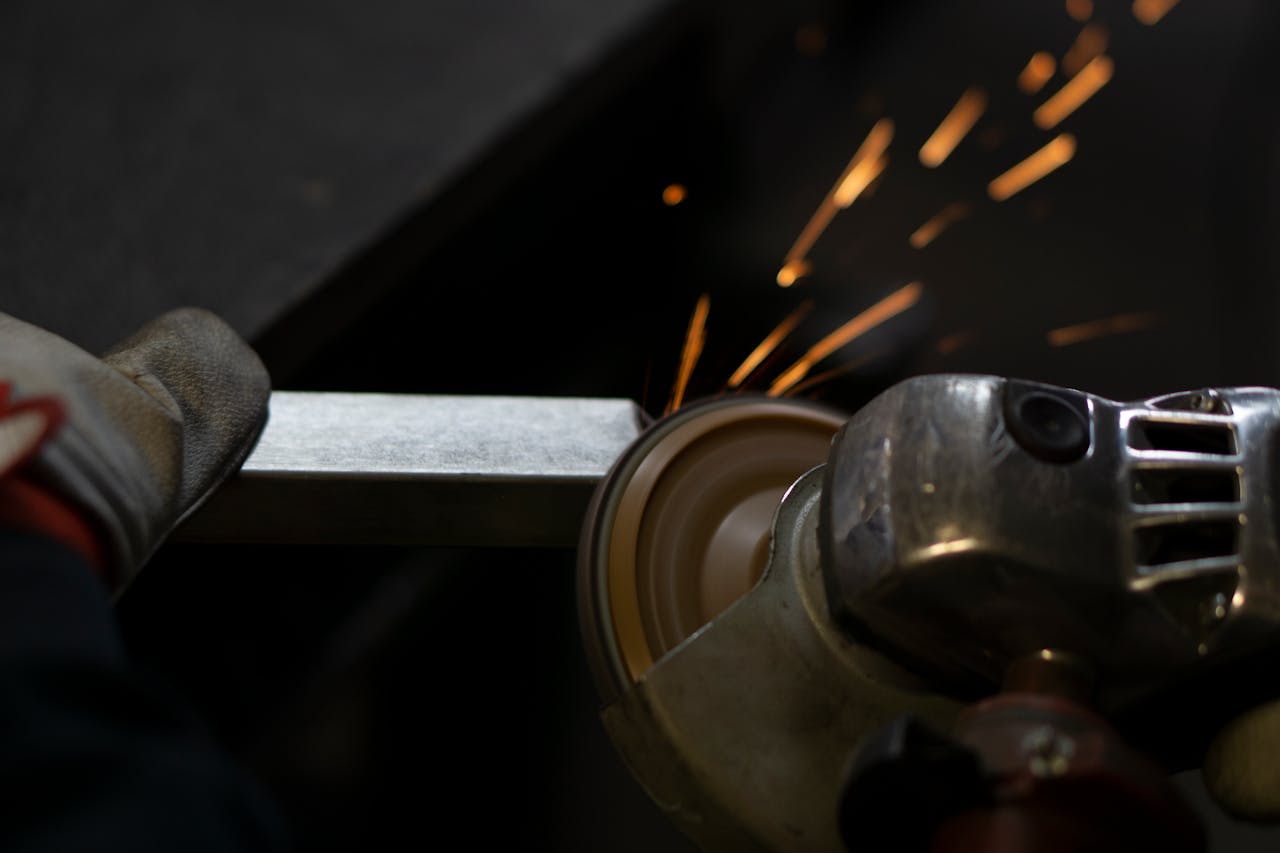 Angle grinder working on steel, emitting bright sparks. Industrial close-up shot.